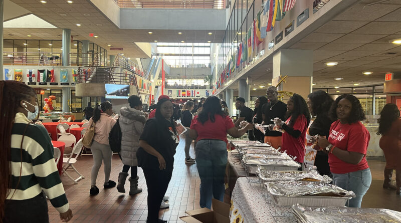 York College students at walking in the atrium as SGA members prepare to share food for their annual Thanksgiving dinner.